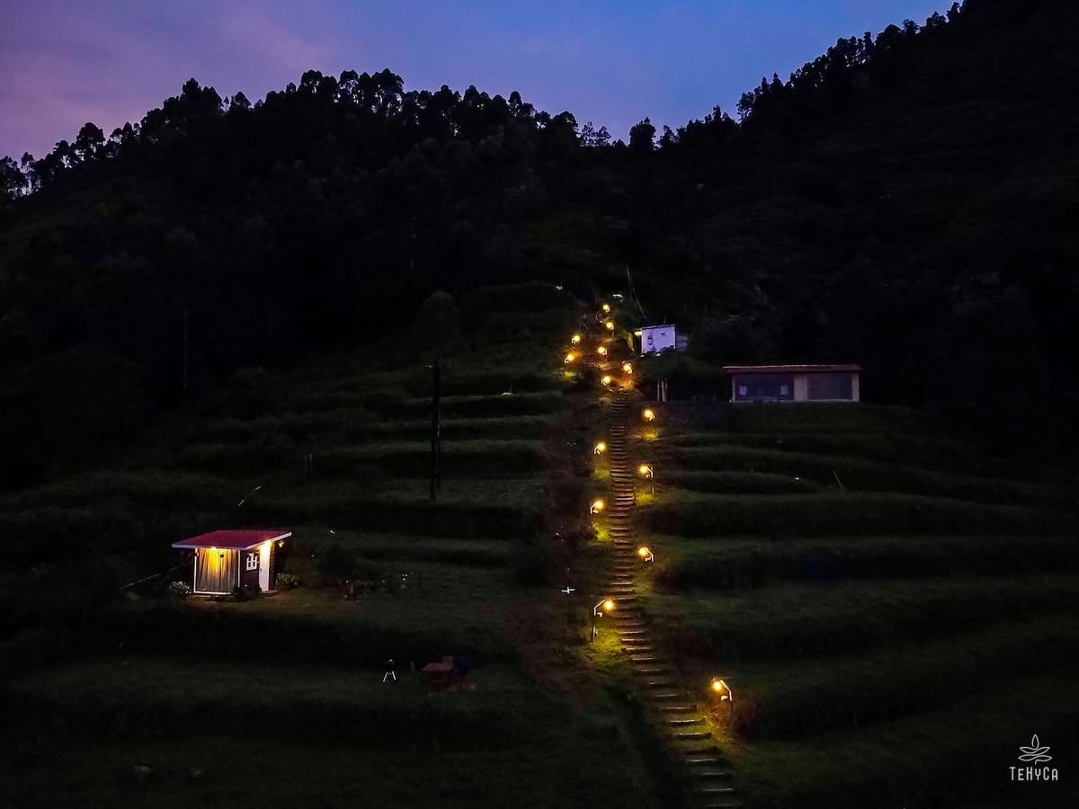 Tehyca — aerial lit staircase climbing the mountain at blue hour