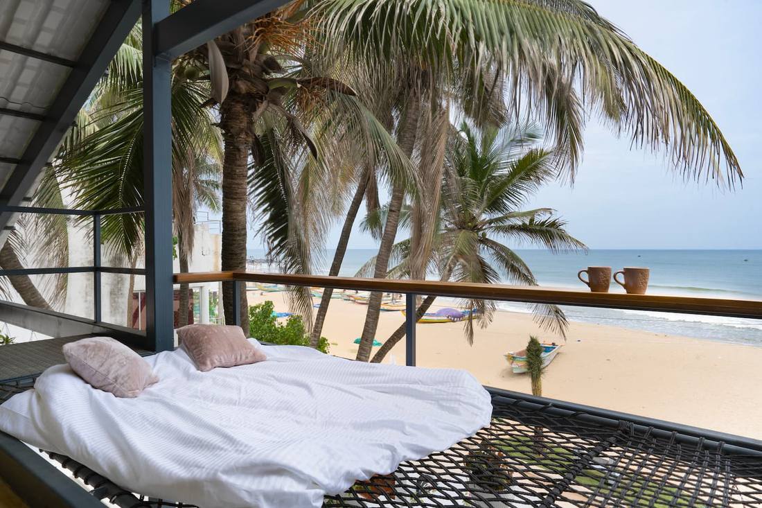 Sea Gadabout Beach Villa — hammock bed overlooking the beach and palm trees