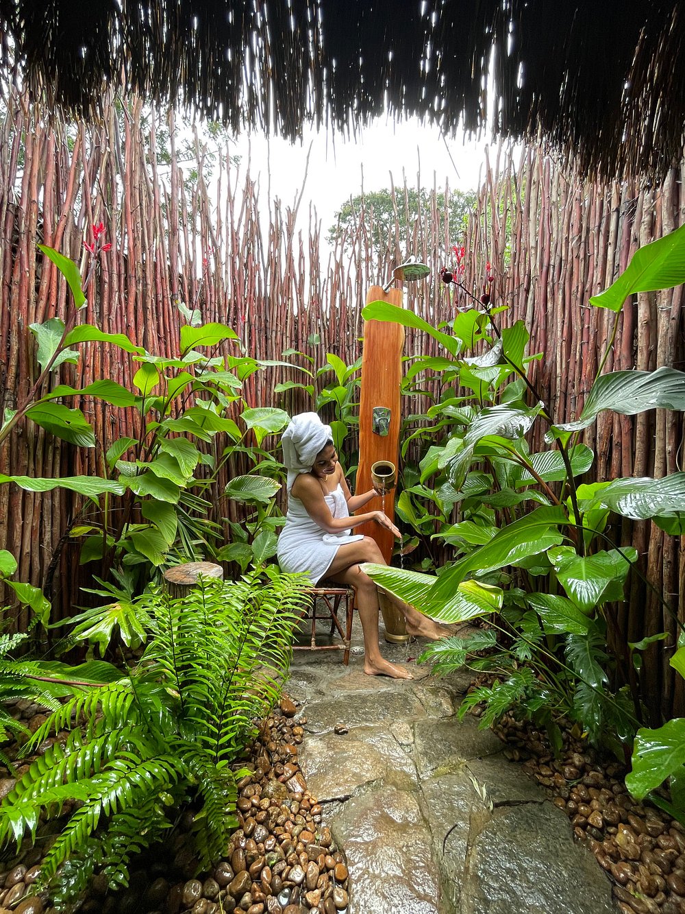 Outdoor bamboo shower surrounded by tropical plants